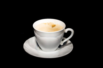black coffee poured from a white mug on a dark background