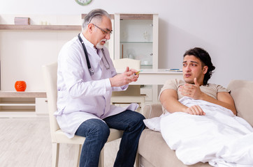 Old male doctor visiting young male patient