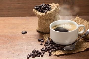 Hot Coffee cup with Coffee beans on the wooden table