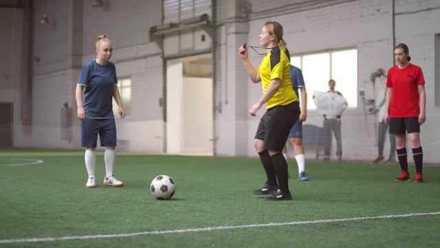 Sequence of shots of female soccer player taking penalty kick but goalkeeper defending the net during match on indoor sports field