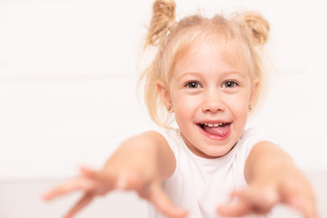 Closeup of blond young girl's face fooling around, smile and laugh. Selective focus