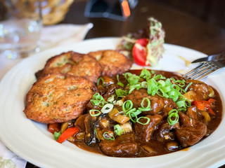 traditional czech goulash dish with fried potatoes & spring onion