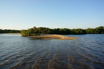 the atmosphere of the beach or the coast before the afternoon with calm waves and sunny weather set against the background of the high seas and mountains or plateaus