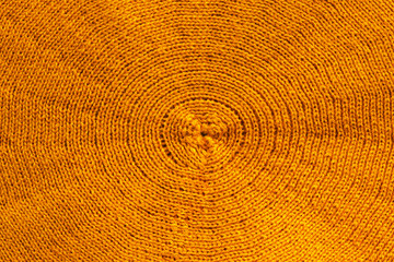 Knitted fabric background with concentric pattern from organic alpaca yellow woolen yarn. Fashion...