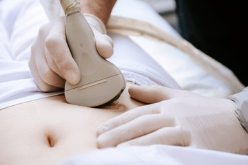 Ultrasound scanner device in the hand of a professional doctor examining his patient doing...