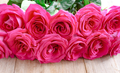 Fototapeta na wymiar Valentines day background with pink roses over wooden table. Top view. Copy space