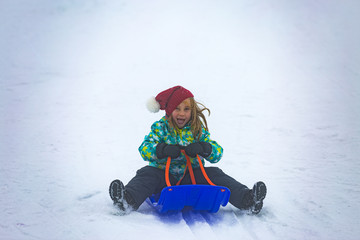 Fototapeta na wymiar Mädchen beim Schlittenfahren im Schnee, Feldberg, Schwarzwald
