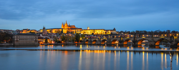 Prague skyline and bridge over river in night
