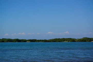 the atmosphere of the beach or the coast before the afternoon with calm waves and sunny weather set against the background of the high seas and mountains or plateaus