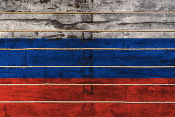 National flag  of Russia on a wooden wall background. The concept of national pride and a symbol of the country. Flags painted on a wooden fence with a rope
