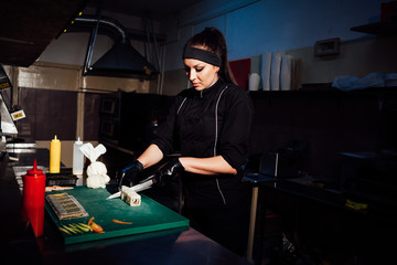 woman chef prepares fresh sushi in the kitchen of the restaurant