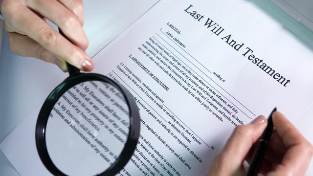 Heir reading last will and testament form using magnifier, legal conditions