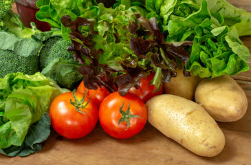 Selected fresh vegetables for salad and meals on wooden table. Healthy eating and diet food.