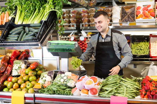 Male seller is weighing grapes