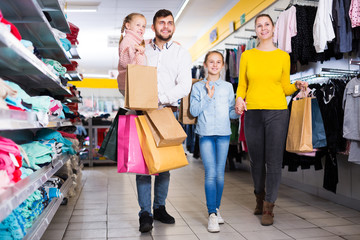 family of four with shopping bags walking