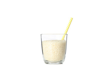 Glass with rice and straw isolated on white background