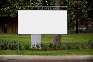 Large white empty banner for advertising close-up in city Park against nature background