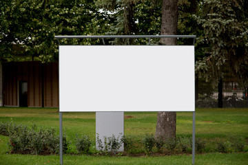 Large white empty banner for advertising close-up in city Park against nature background