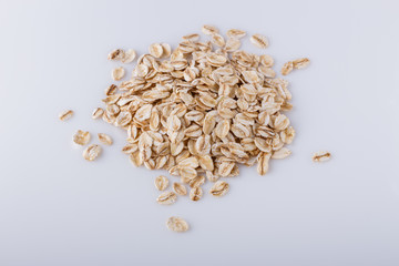 raw oat flakes on white acrylic background