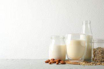 Bootle and glass of different types milk on gray background, space for text