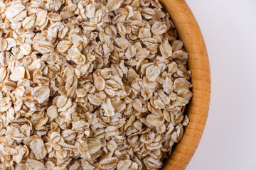 raw oat flakes on white acrylic background