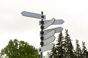 information. white iron blank direction indicator closeup background white sky and trees
