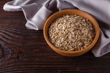raw oatmeal on a wooden rustic background