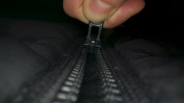 Closing a zipper. Pont of view macro shot towards camera.
