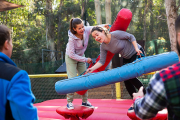 Female friends fighting by inflatable logs