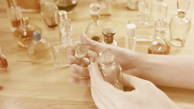 Vintage perfumers bottles in hands of a girl