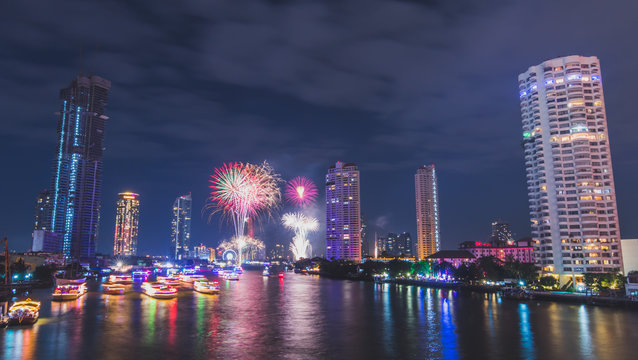 Fireworks on nre year countdown with the building the river around at Chaopraya river, Taksin bridge, Thailand.