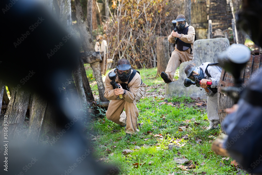 Wall mural People playing paintball outdoors