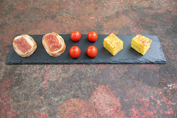 Selection of spanish tapas ham iberico with bread tomatoes potato tortilla culinary delicious food potatoes tomato on a rusty table healthy from above top down
