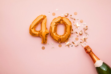 Happy 40th anniversary party. Champagne bottle with gold number balloon.