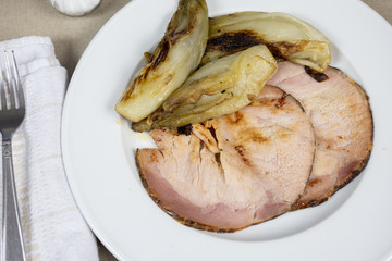 roast pork and braised endives on a plate