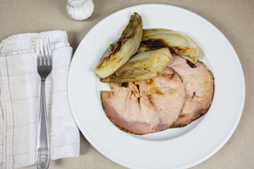 roast pork and braised endives on a plate