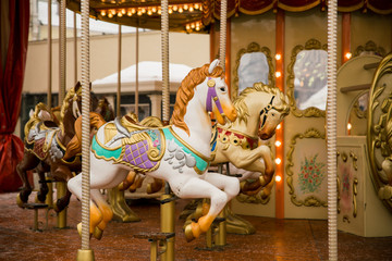 Fototapeta na wymiar merry go round carousel with white horse closeup