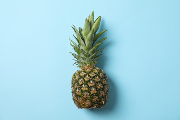 Pineapple on blue background, space for text. Juicy fruit