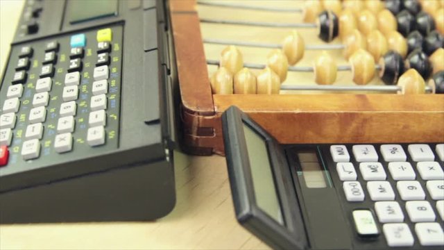 Wooden abacus and retro calculators
