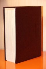 thick book on orange background