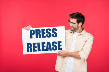 handsome man holding white placard with press release illustration isolated on red