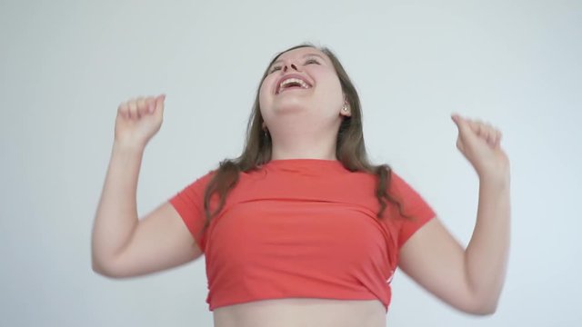 Body positive concept. Fat girl dancing and smiling with bare belly.