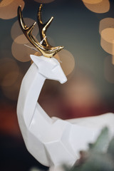 Close up of white deer figurine on the festive table. New Year eve concept