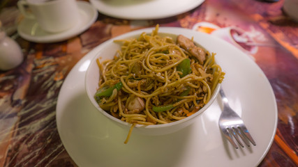 A dish of noodles with chicken and vegetables.