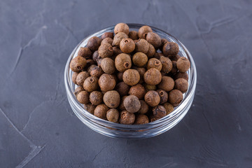 fresh spicy peppers allspice on a dark stone background