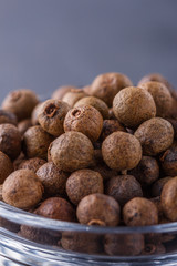 fresh spicy peppers allspice on a dark stone background
