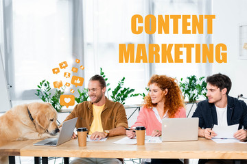 three friends smiling and looking at cute golden retriever in office with content marketing illustration