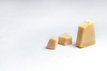 Pieces of parmesan or parmigiano cheese on a white board