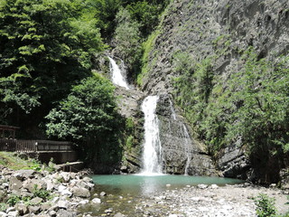 Green and clean waterfall in summer in mountains