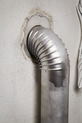 ein Ofenrohr eines Kohleofens welches im Zugang zum Schornstein steckt